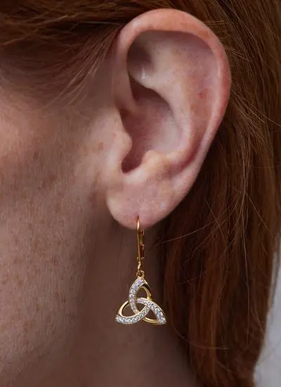 Close up of red haired model wearing 14Ct Gold Vermeil Trinity Knot Drop Earrings with Cubic Zirconia